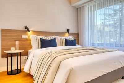 a bedroom with a large bed and a window at Funchal Acqua Blue 5L, a Home in Madeira in Funchal
