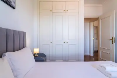 a bedroom with a white bed and a closet at GuestReady - Caniço city view in Caniço