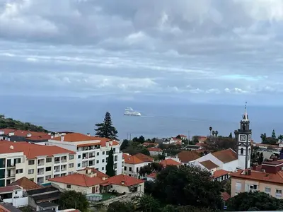 a cruise ship in the ocean behind a city at GuestReady - Caniço city view in Caniço