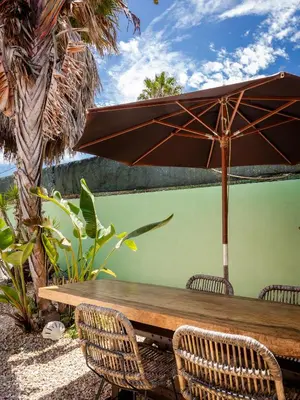 a wooden table with an umbrella and chairs at Casa Pinho Vista in Aljezur