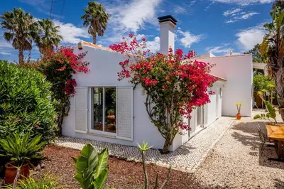 a white house with flowers on the side of it at Casa Pinho Vista in Aljezur