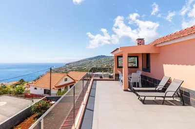 a house with a balcony with a view of the ocean at Casa Por Do Sol ll in Arco da Calheta