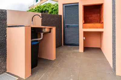 a bathroom with a sink next to a building at Casa Por Do Sol ll in Arco da Calheta