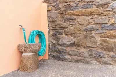 a hose is hooked up to a stone wall at Casa Por Do Sol ll in Arco da Calheta