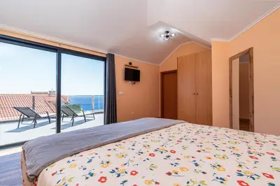 a bedroom with a bed and a view of the ocean at Casa Por Do Sol ll in Arco da Calheta