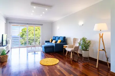 a living room with a blue couch and chairs at GuestReady – Stay Near Historic Reis Magos Fort in Caniço