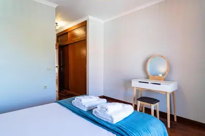 a bedroom with a bed and a desk with a mirror at GuestReady – Stay Near Historic Reis Magos Fort in Caniço