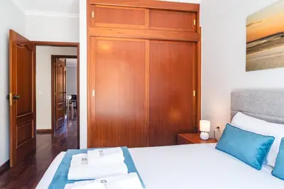 a bedroom with a bed and a wooden door at GuestReady – Stay Near Historic Reis Magos Fort in Caniço