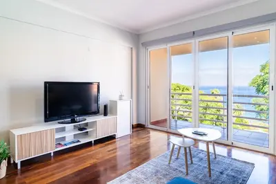 a living room with a tv and a large window at GuestReady – Stay Near Historic Reis Magos Fort in Caniço