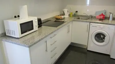 a kitchen with a microwave and a washing machine at João & Amália apartment by Rentallido in Funchal