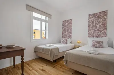 a bedroom with two beds and a desk and a window at The Graceful Manor by Homie in Funchal