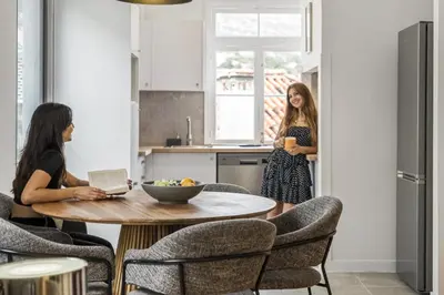 two women standing in a kitchen with a table at The Graceful Manor by Homie in Funchal