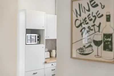 a kitchen with a refrigerator and a picture of wine glasses at The Graceful Manor by Homie in Funchal