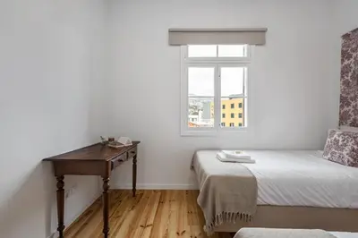 a bedroom with a bed and a desk and a window at The Graceful Manor by Homie in Funchal