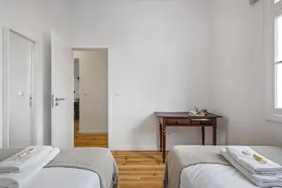 a white room with two beds and a table at The Graceful Manor by Homie in Funchal