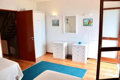 a bedroom with white dressers and a mirror at Casa Mareta in Sagres