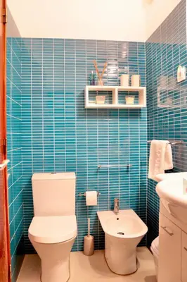 a blue tiled bathroom with a toilet and a sink at Casa Mareta in Sagres