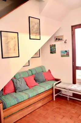 a living room with a green couch with red pillows at Casa Mareta in Sagres
