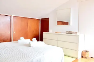 a white bedroom with a white bed and a dresser at Casa Mareta in Sagres