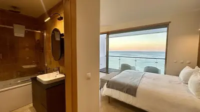 a bathroom with a bed and a view of the ocean at Luz by Check-in Portugal in Luz