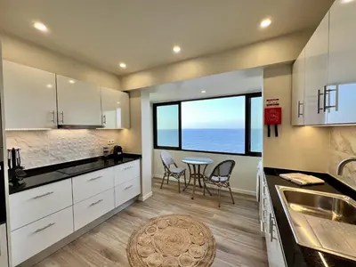 a kitchen with a table and a view of the ocean at Ocean Horizon in Funchal