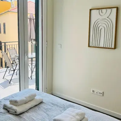 a room with two towels on a bed with a balcony at Carmo Heritage Terrace in Funchal