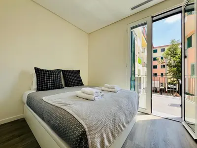 a bedroom with a bed and a large window at Carmo Heritage Terrace in Funchal
