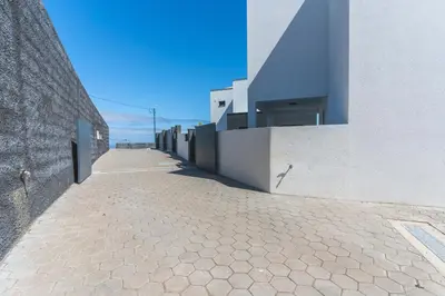 a building with a stone sidewalk next to a building at Blue Outlook Garden by Atlantic Holiday in Água de Pena