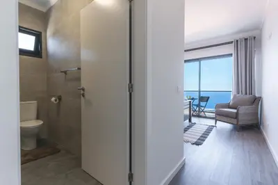 a bathroom with a toilet and a view of the ocean at Blue Outlook View by Atlantic Holiday in Água de Pena