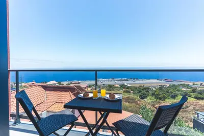 a table and chairs on a balcony with a view of the ocean at Blue Outlook View by Atlantic Holiday in Água de Pena