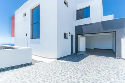 a white house with a garage at Blue Outlook View by Atlantic Holiday in Água de Pena