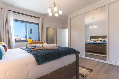 a bedroom with a bed with a table and a window at Blue Outlook View by Atlantic Holiday in Água de Pena