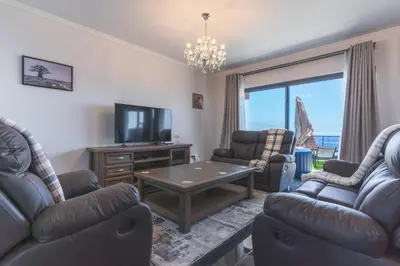a living room with couches and a tv and a table at Blue Outlook View by Atlantic Holiday in Água de Pena