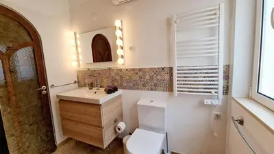 a bathroom with a toilet and a sink and a mirror at Casa Contente 3-bedroom villa with pool in Luz