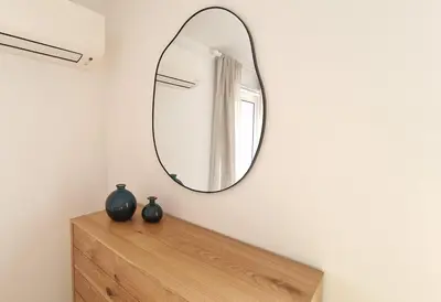 a mirror on a wall above a wooden dresser at Casa Contente 3-bedroom villa with pool in Luz