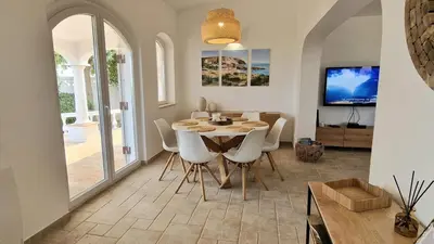a dining room with a table and white chairs at Casa Contente 3-bedroom villa with pool in Luz