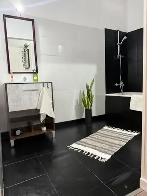 a black and white bathroom with a sink and a mirror at São Lourenço 3 in Caniçal