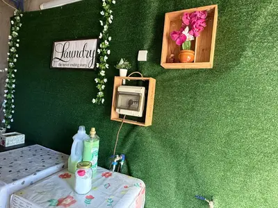 a room with a green wall with a bed and a table at São Lourenço 3 in Caniçal