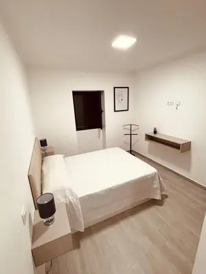 a white bedroom with a bed and a tv at Vila Ramos II-Funchal in Funchal