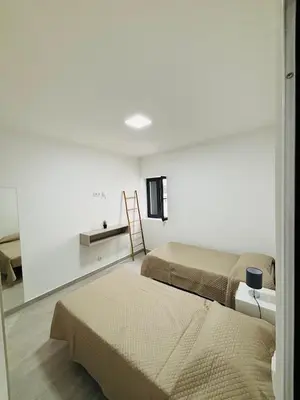 a room with two beds and a table with a ladder at Vila Ramos II-Funchal in Funchal