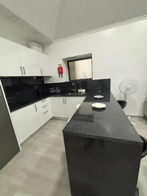 a kitchen with a black counter and white cabinets at Vila Ramos II-Funchal in Funchal