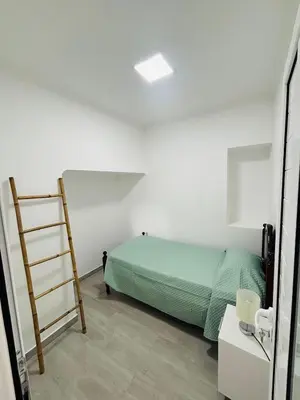 a bedroom with a green bed and a ladder at Vila Ramos II-Funchal in Funchal