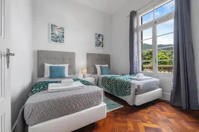 a bedroom with two beds and a window at Akosuah's Villa in Funchal
