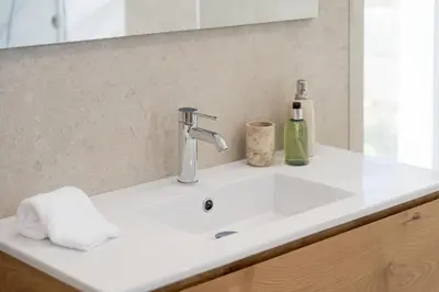 a bathroom sink with a faucet and a bottle of soap at Villa Meridian by Destination Algarve in Mato Porcas