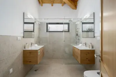 a bathroom with two sinks and a shower at Villa Meridian by Destination Algarve in Mato Porcas