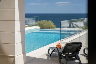 a black chair sitting next to a swimming pool at Villa Meridian by Destination Algarve in Mato Porcas