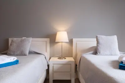 a bedroom with two beds and a table with a lamp at St James 30 by Destination Algarve in Luz