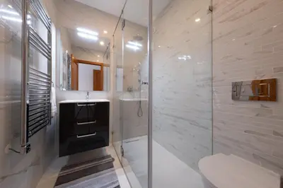a bathroom with a shower and a sink and a toilet at St James 30 by Destination Algarve in Luz