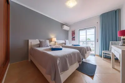 a hotel room with two beds and a window at St James 30 by Destination Algarve in Luz