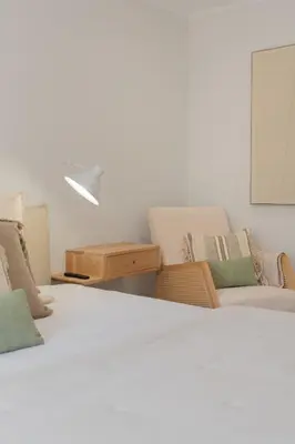 a bedroom with two beds and a table and chairs at Promenade II by An Island Apart in Funchal